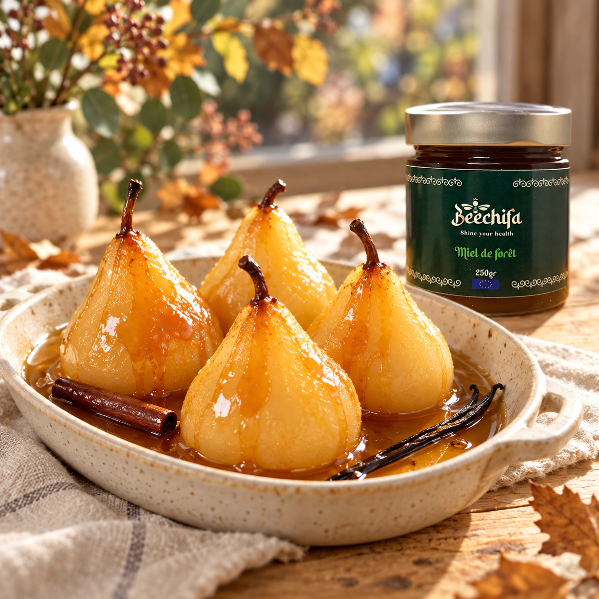 Poires pochées dans un sirop ambré, cannelle et vanille, à côté d’un pot de miel de forêt Beechifa.